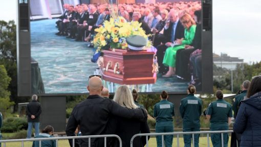 Members of the public gathered outside the stadium to watch the service on a big screen. Picture: NCA NewsWire / Sharon Smith