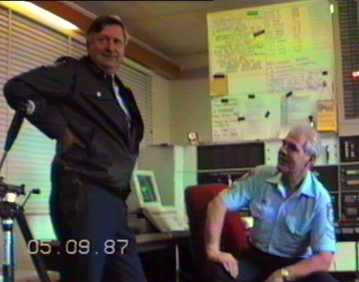 THESE PHOTOS ARE 'GRABBED' FROM VIDEO TAPE FROM 'VARIOUS 4' OF THE COLLECTION OF GREG CALLANDER.<br /> 1987 - 1988<br /> <br />Video transferred to DVD on 230206<br /> <br />SENIOR CONSTABLE <strong><a href="https://dev.australianpolice.com.au/karl-hanson/" target="_blank" rel="noopener noreferrer">KARL HANSON</a></strong> # 8870  (SEATED), VKG2, WARILLA POLICE RADIO - SENIOR OPERATIONS OFFICER - SPEAKING WITH SENIOR SERGEANT <a href="https://dev.australianpolice.com.au/richard-alan-brook/" target="_blank" rel="noopener noreferrer"><strong>DICK BROOK</strong></a> # 9570, FROM WARILLA POLICE STATION.<br /> <br /> 1987 - 1988
